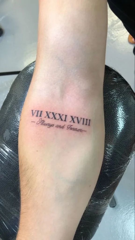 Tatouage dans le coude d'une date en chiffre romain homme