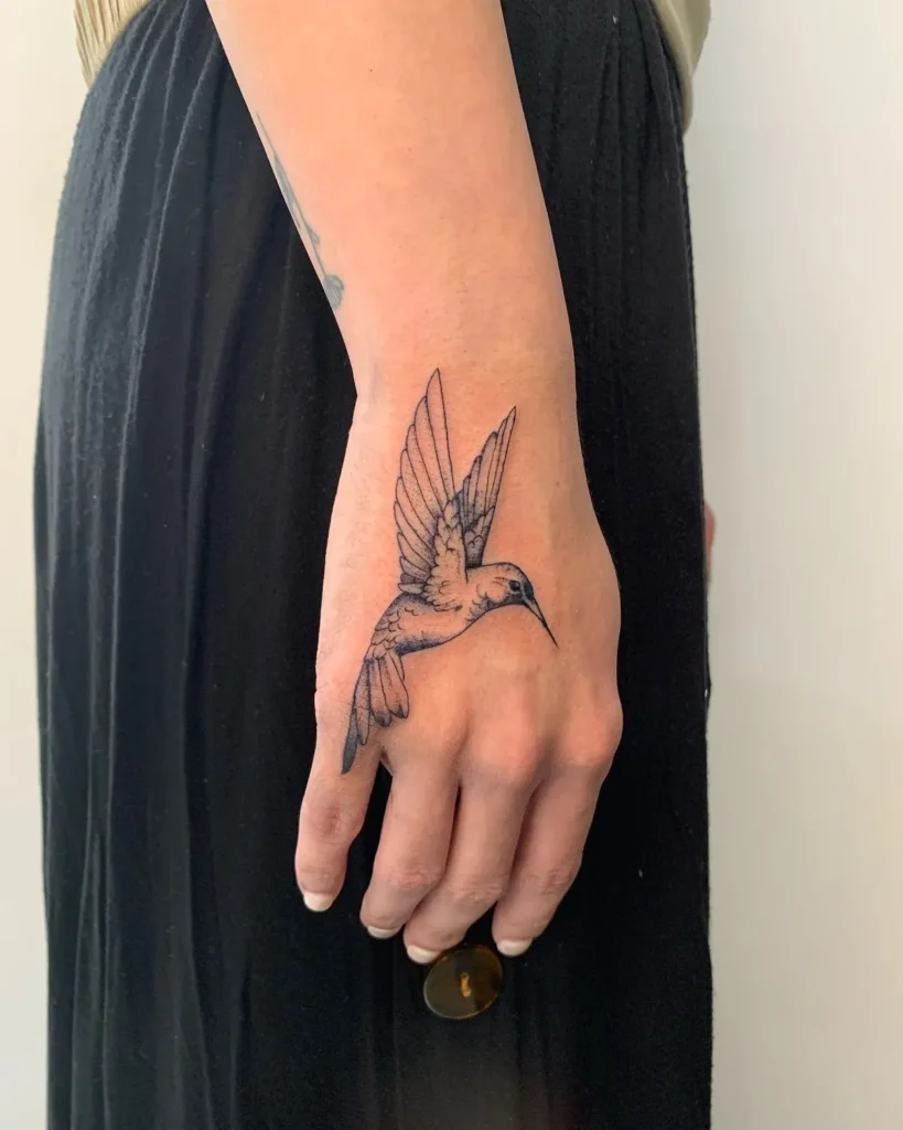 Tatouage colibri sur la main d'une femme