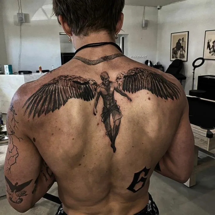 Tatouage d'un ange déployant ses ailes dans le dos d'un homme musclé