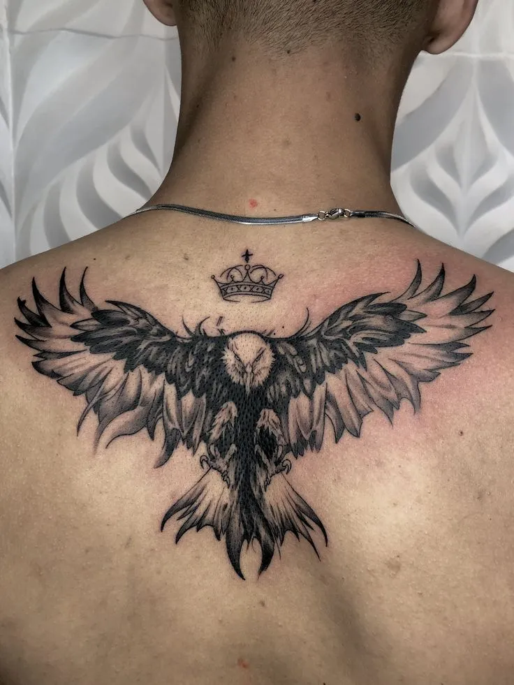 Tatouage d'un aigle écartant ses ailes dans le dos d'un homme, symbole de force