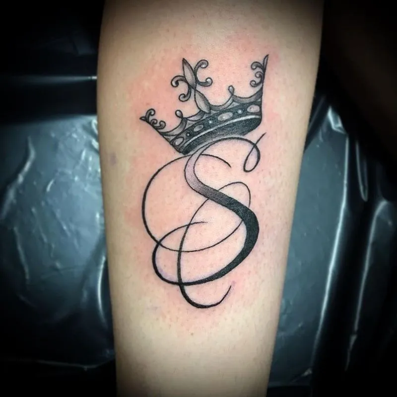 Tatouage de la lettre S avec une couronne au dessus