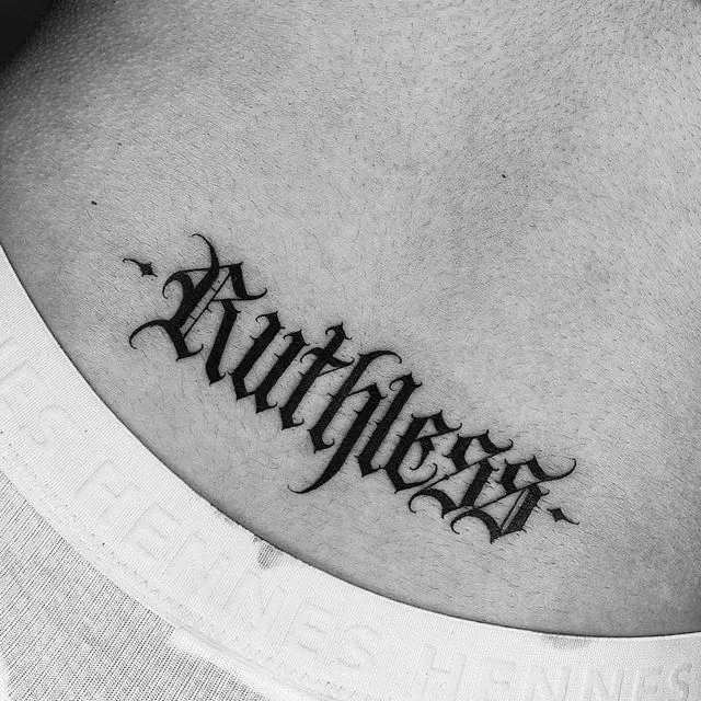 Tatouage de lettres symbolisant d'être impitoyable dans le bas du dos d'une femme