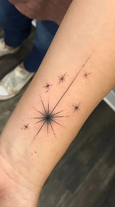 Tatouage étoile filante sur le bras, minimaliste et fin