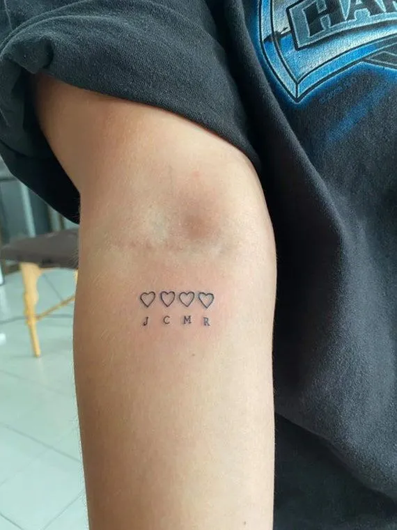 Tatouage minimaliste de la famille avec quatre cœurs