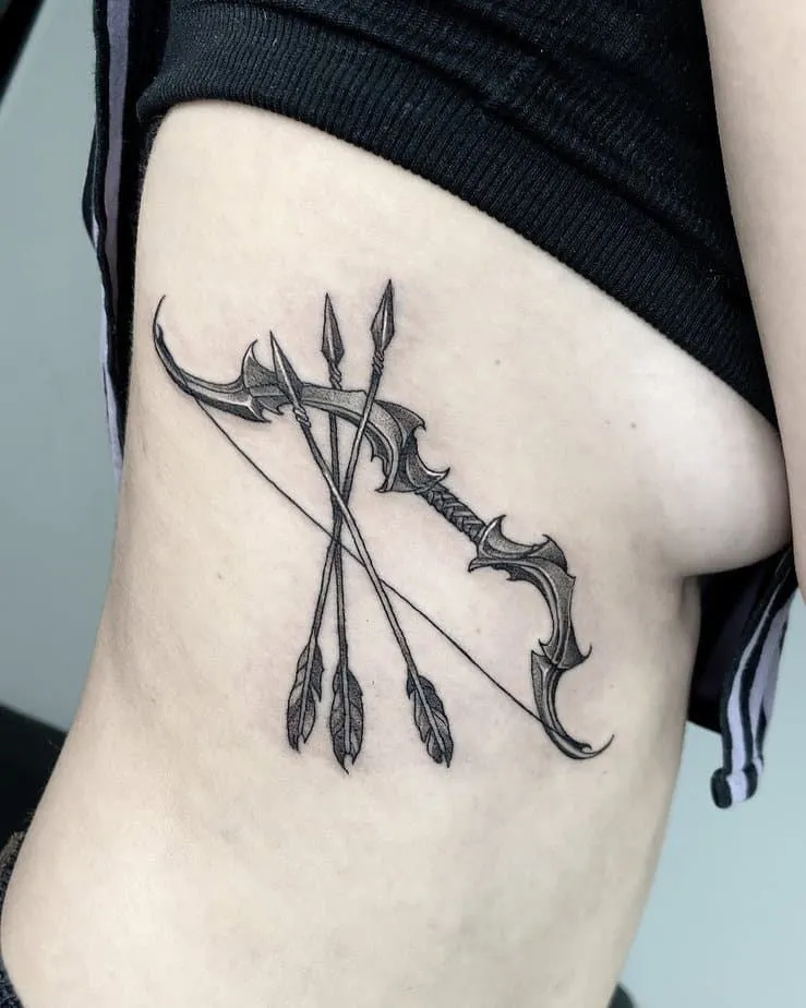Tatouage sur les côtes d'une femme d'un arc et de flèches 