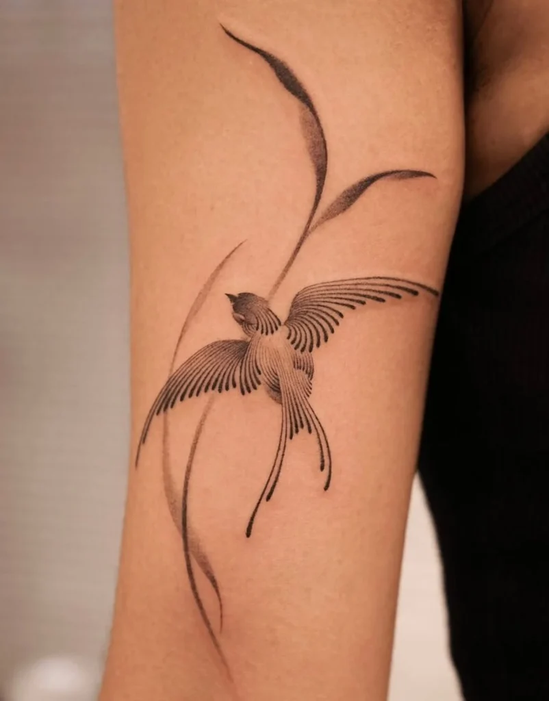 Tatouage d'hirondelle fin sur le bras femme