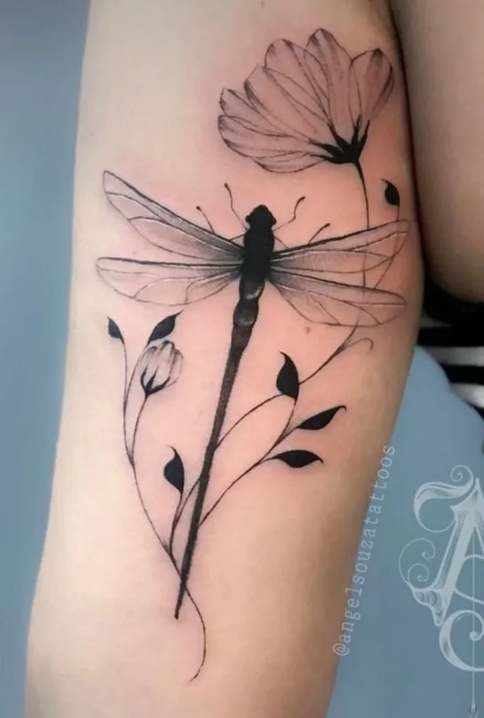 Tatouage de libellule avec une fleur sur le bras d'une femme