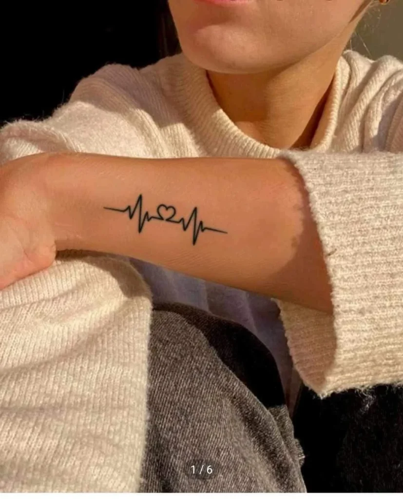 Tatouage ligne de vie avec un cœur sur le bras d'une femme
