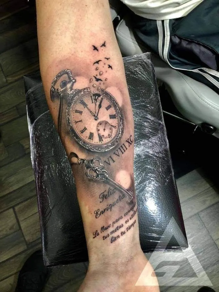 Tatouage montre à gousset avec une clé sur l'avant bras d'un homme

