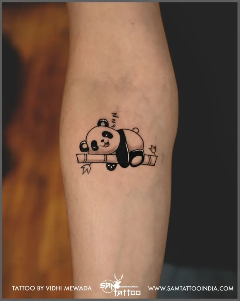 Tatouage d'un panda dormant sur une branche de bambou