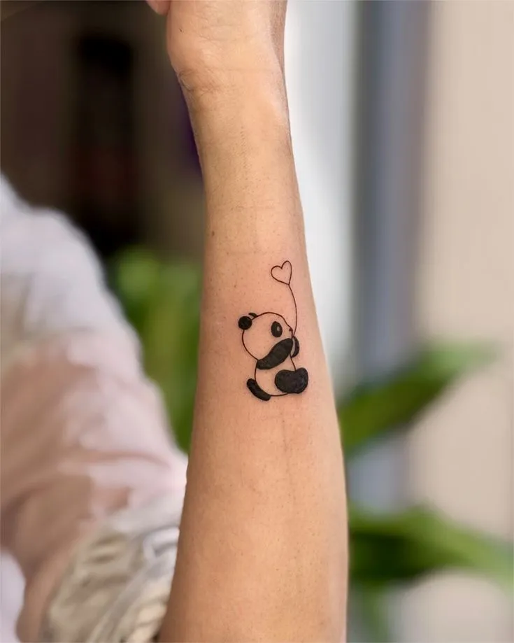 tatouage panda minimaliste à l'avant bras d'une femme