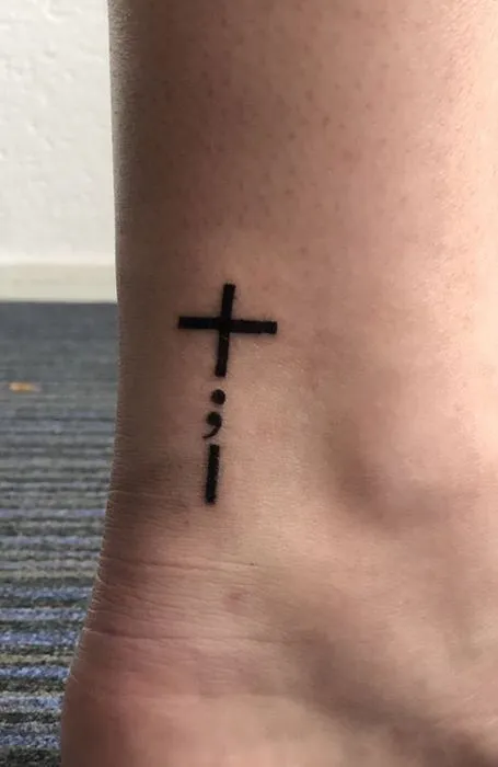 Tatouage point virgule dans une croix religieuse