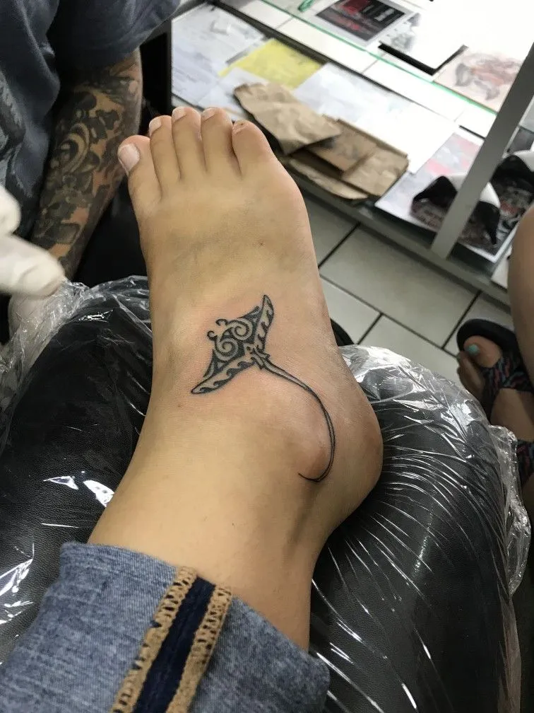 Tatouage d'une raie manta sur le pied d'une femme