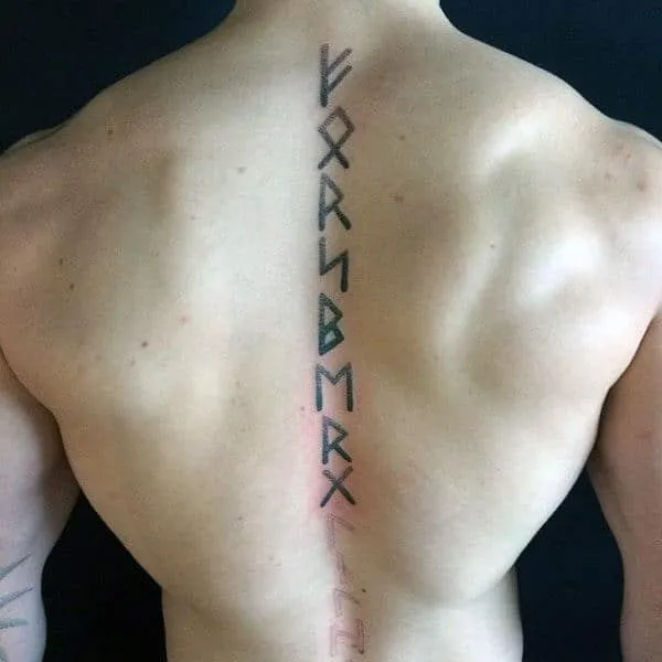 Tatouage rune viking sur la colonne vertébrale d'un homme musclé 