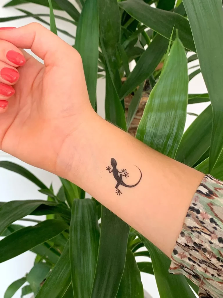 Tatouage minimaliste d'une salamandre sur le poignet