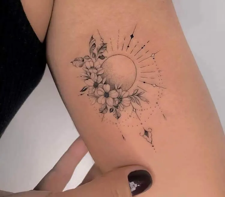 Tatouage soleil et floral sur le bras d'une femme