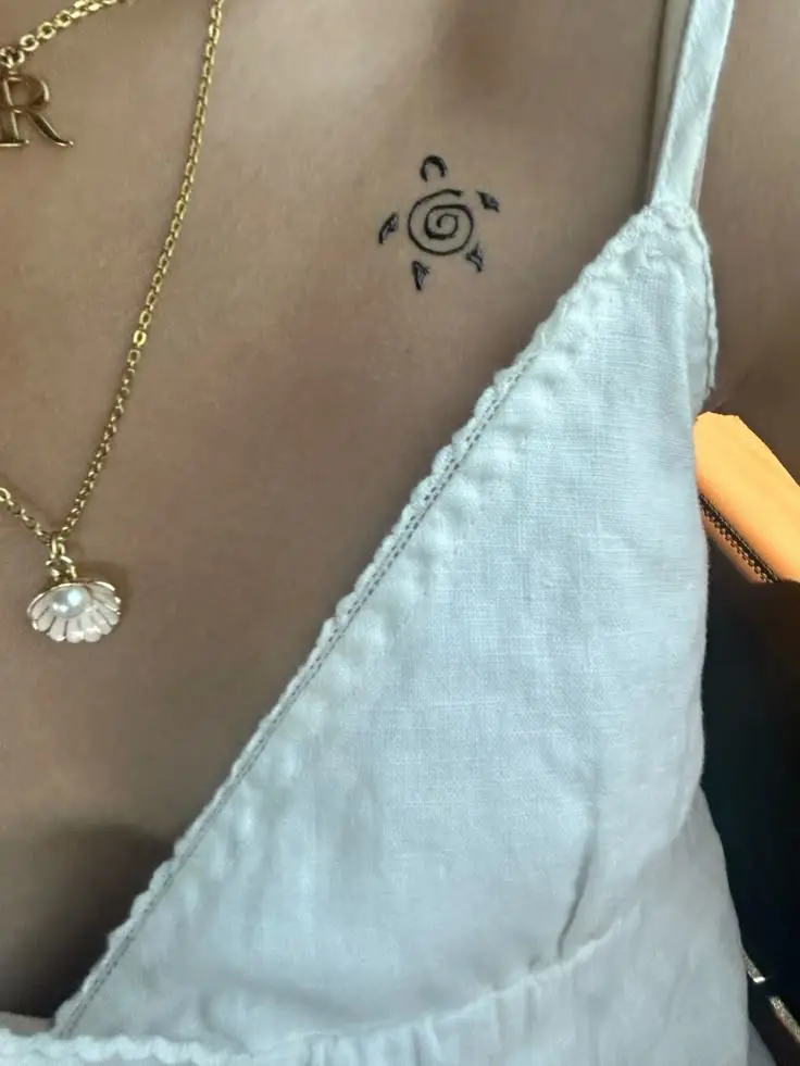 Tatouage minimaliste d'une tortue au dessus de la poitrine d'une femme