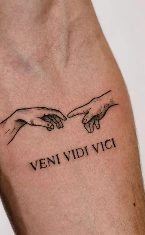 Tatouage de 2 doigts se rejoignant avec écrit veni vidi vici en dessous