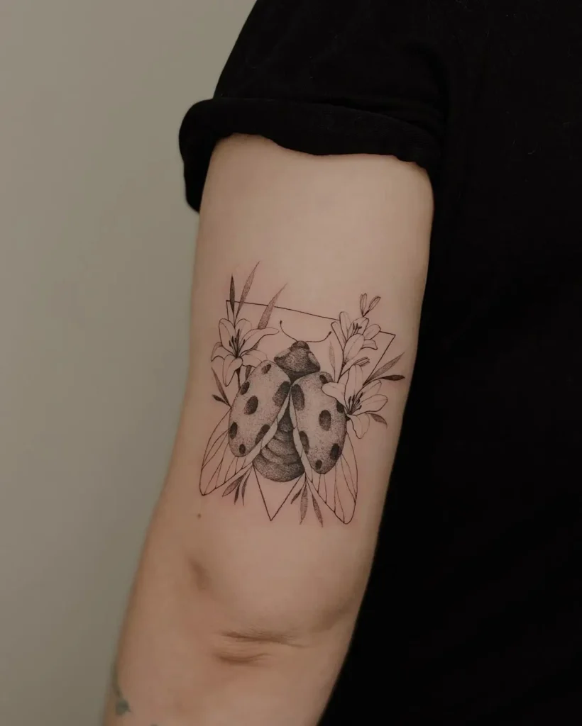 Tatouage coccinelle prenant son envol, sur l'arrière bras d'un homme
