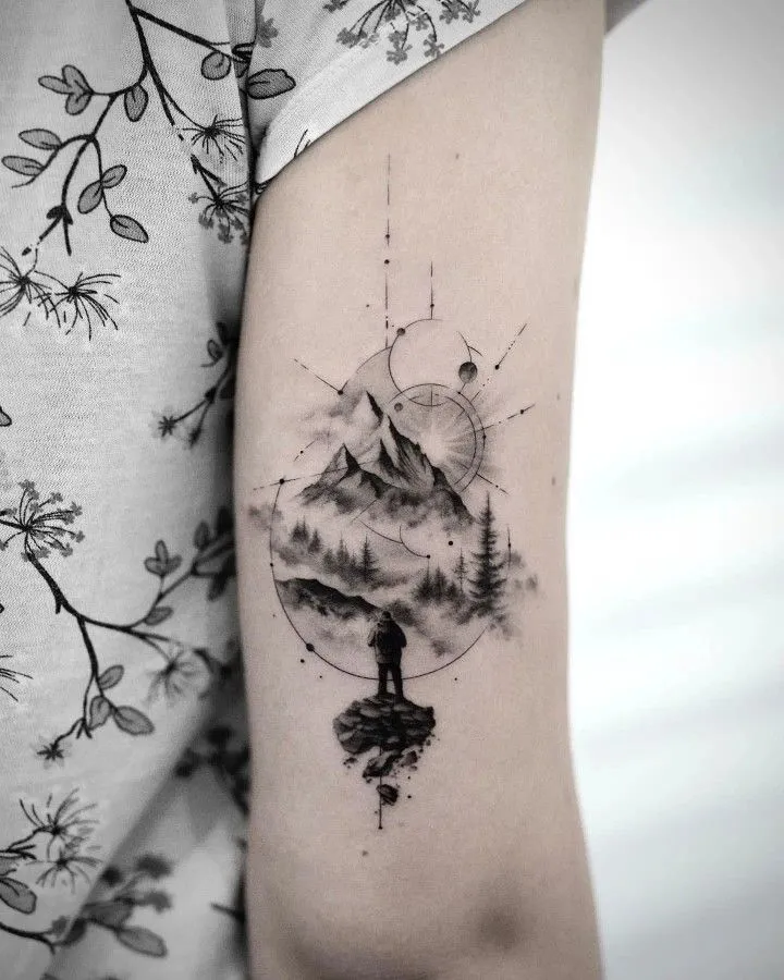 Tatouage montagne géométrique sur le bras d'une femme